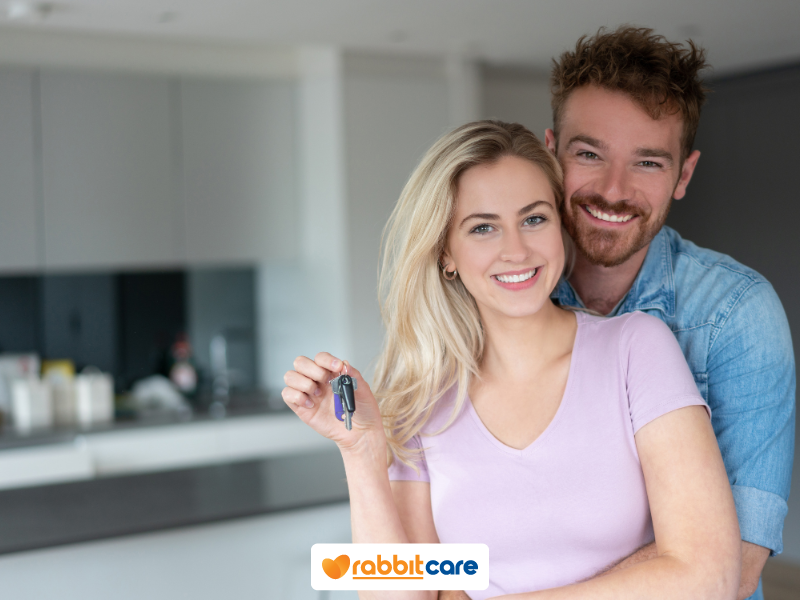 Vợ chồng cầm chìa khoá nhà trong nhà vui vẻ